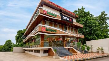 A multi-story hotel with a prominent 'ESSENCE' sign, a 'YO' sign, and a restaurant sign.