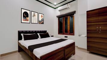 A bedroom with a bed, a wardrobe, and wall-mounted artwork.