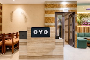 A reception area with a sign reading 'OYO' and a sign for 'ESSENCE RESTAURANT' in the background. - Hotel O Essence Inn (Prayagraj)