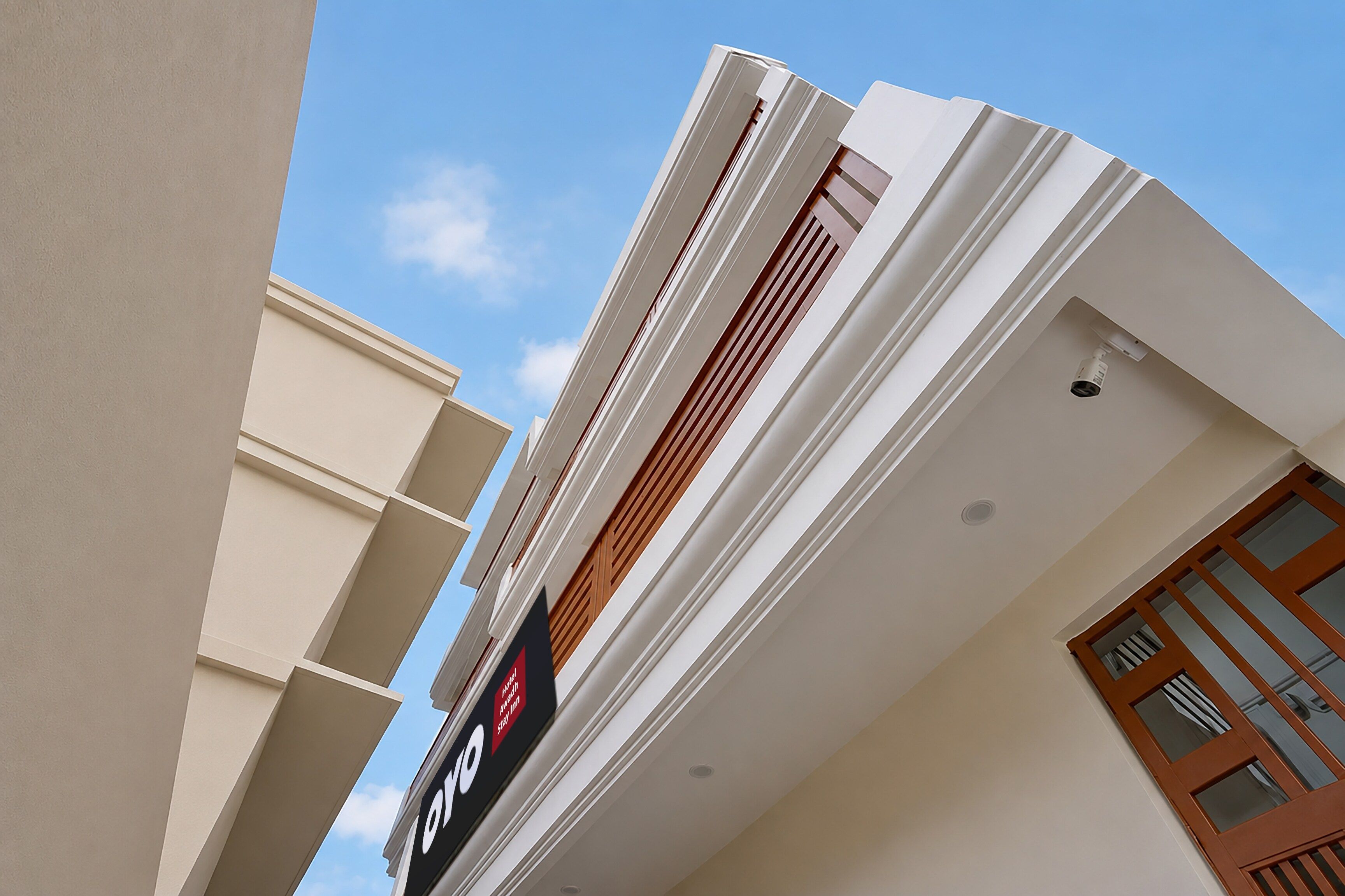 A hotel facade with a modern design, featuring a prominent logo and a sign indicating a hotel award.