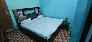 A bedroom with a bed, a nightstand, and a small table with a plant. - Hotel O Sankar Hotel and Restaurant (Bara)