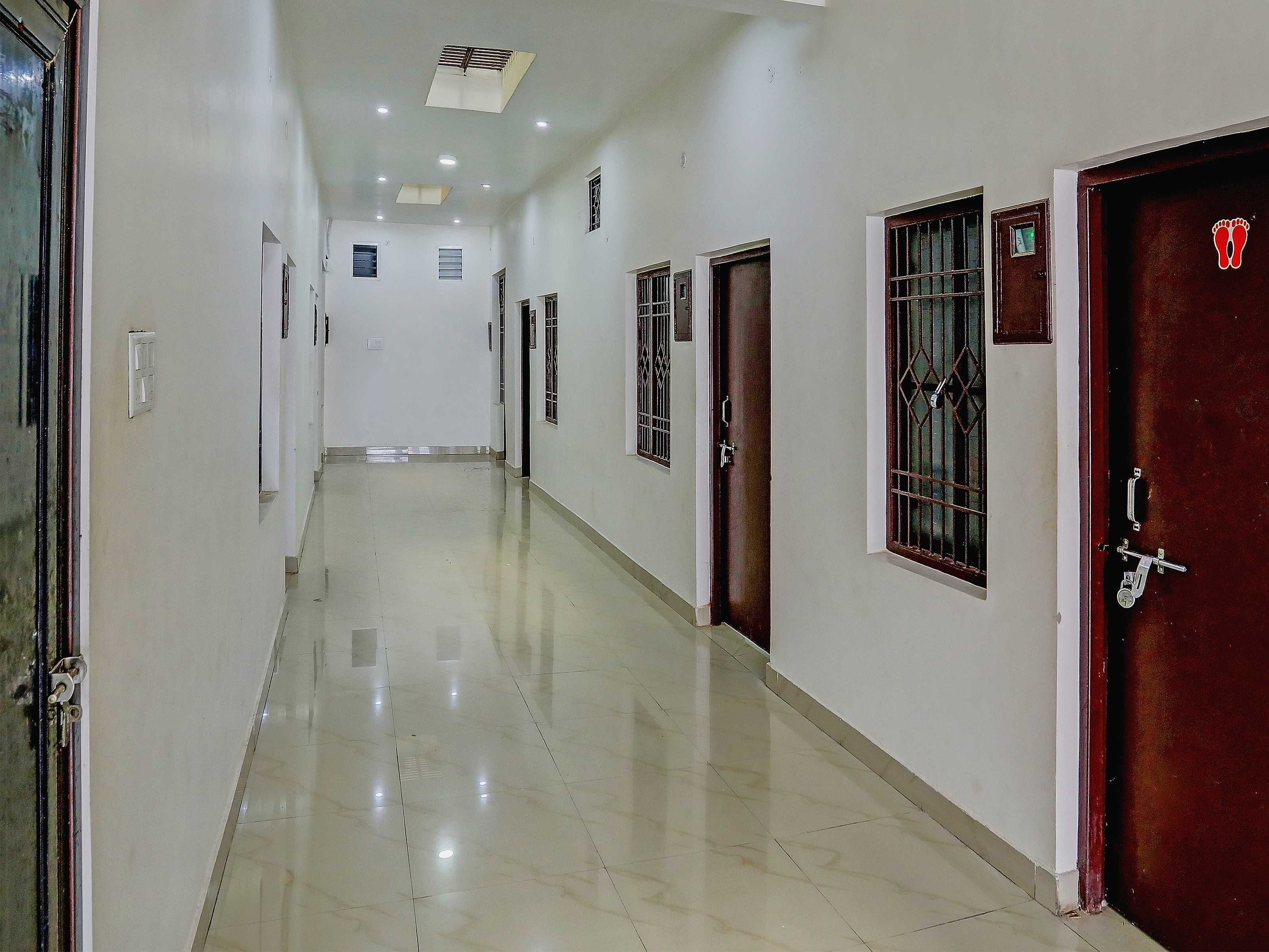 Un pasillo con puertas, piso de baldosas e iluminación empotrada.