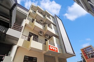 A multi-story building with balconies and air conditioning units.
