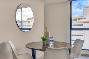 A modern room with a round table, two chairs, a potted plant, and a decorative vase. - New Listing (Bogotá)