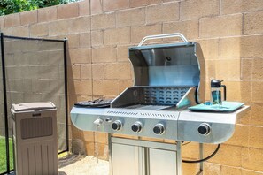 A portable gas grill with four burners, a water container, and a vent. - The Velvet Cactus, Private Pool, Fire Pit, BBQ, & King Bed (Indio)