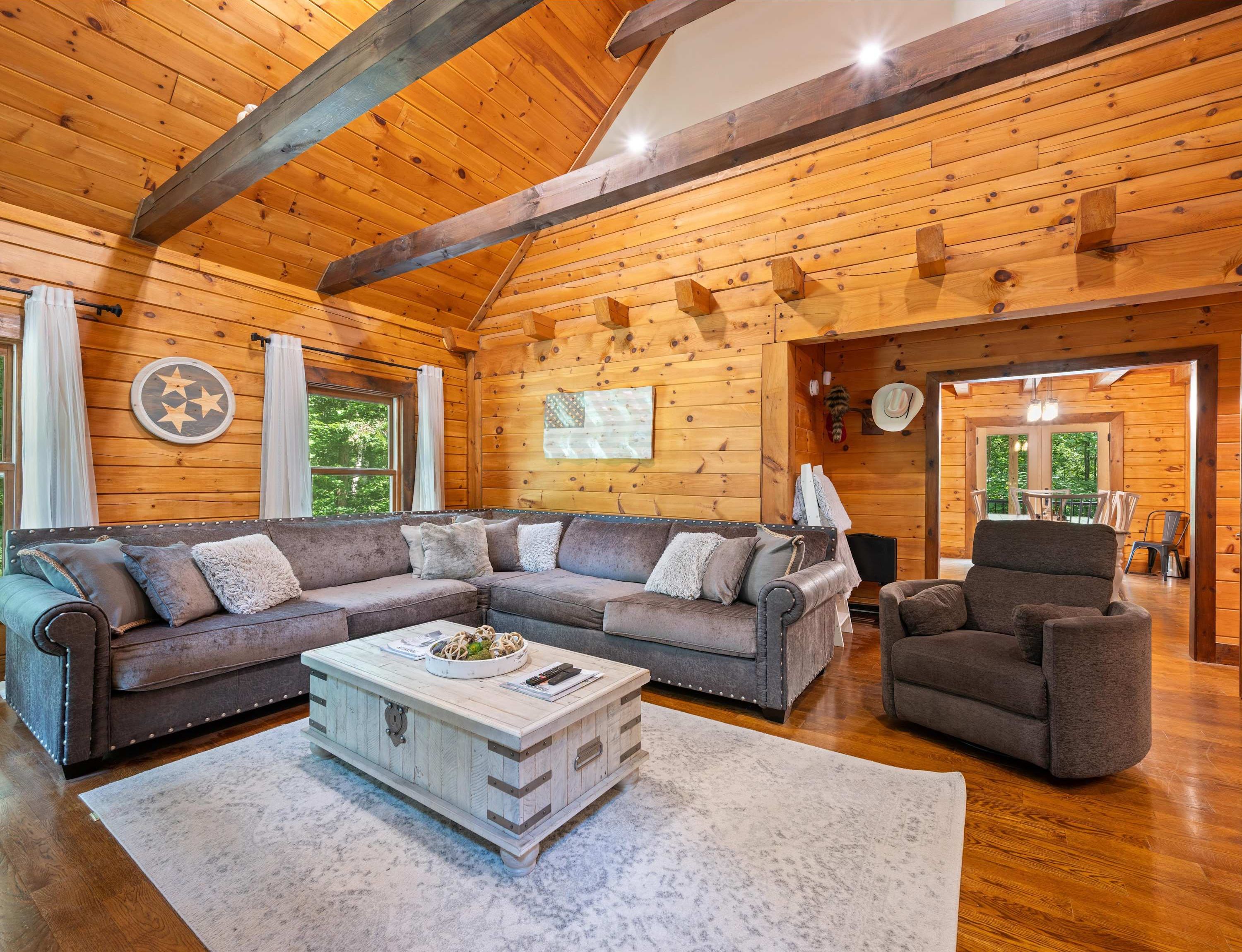 Gather and make memories in the bright, open cabin living room with high ceilings and a spacious sectional