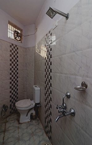 A bathroom with a toilet, a shower, and a sink.