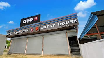 En bygning med et skilt, der viser 'OYO Hotel Rahul Inn Guest House', og et delvist synligt telefonnummer.