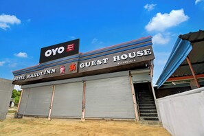 Un bâtiment sur lequel on peut voir une enseigne indiquant « OYO Hotel Rahul Inn Guest House » et un numéro de téléphone partiellement visible.