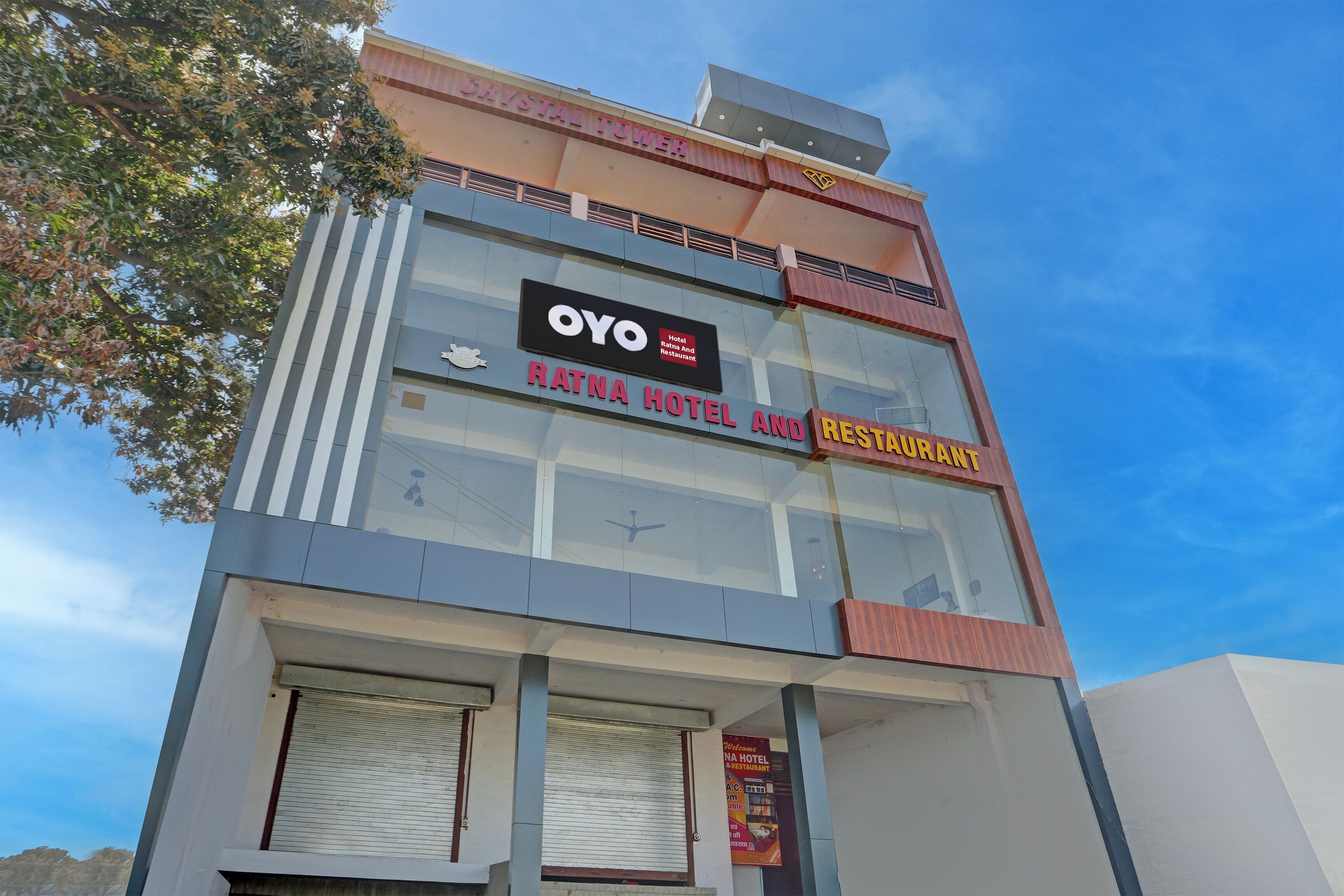 Un hotel y restaurante con un letrero que dice OYO y RATNA HOTEL & RESTAURANT.