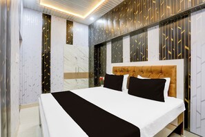 Een hotelkamer met een groot bed, een hoofdeinde en behang met een patroon.