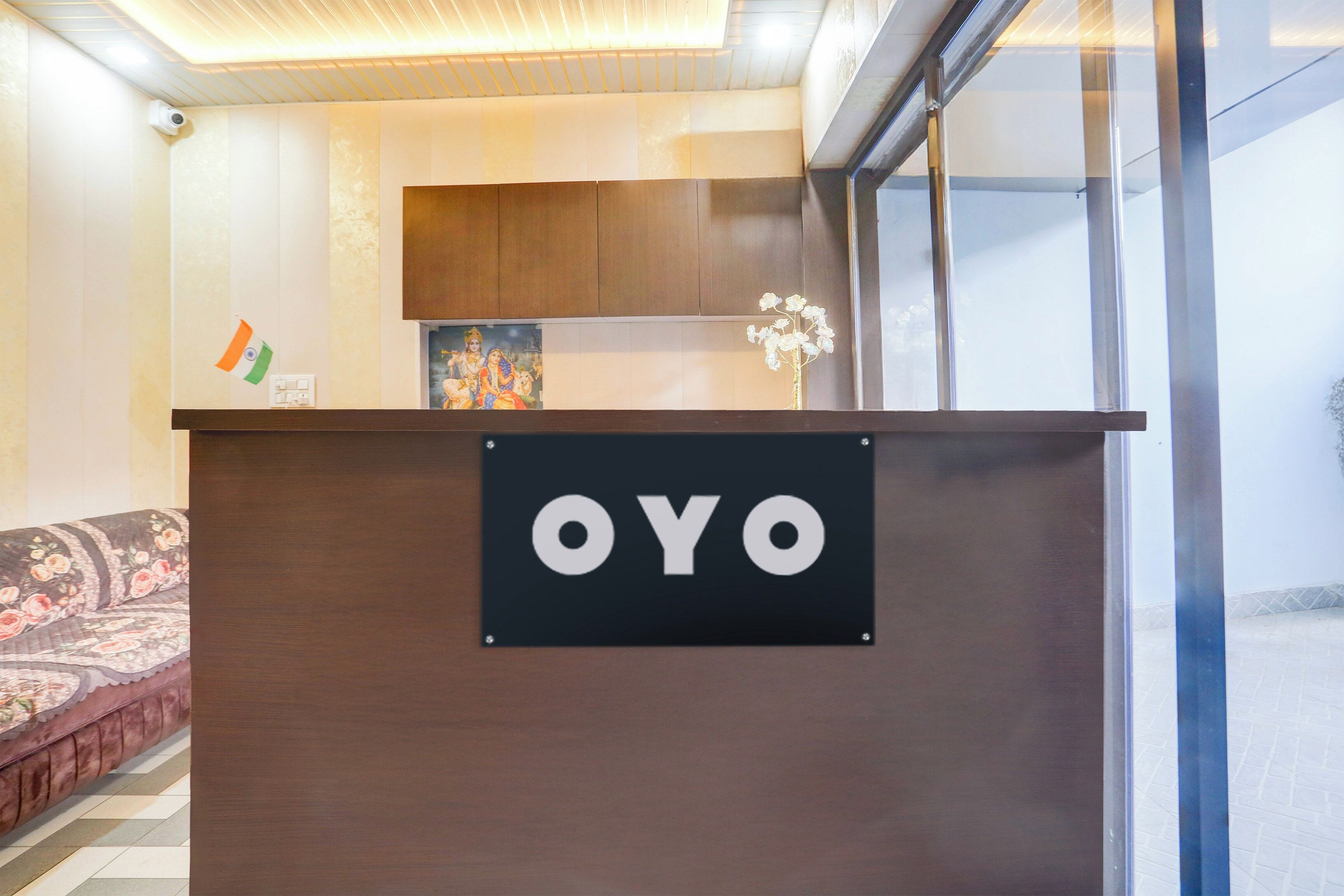 A reception desk with a sign that reads 'OYO' and a framed picture above it.