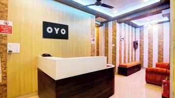 A reception desk with a sign that reads 'OYO' and a no alcohol allowed sign.
