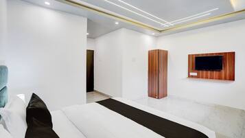 Un dormitorio moderno con cama, armario y televisor montado.