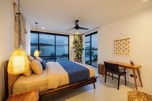 A modern bedroom with a large bed, a desk, and a chair. - 2BR Private Pool Villa with Rice Field Views & Sunset Balconies (Badung)