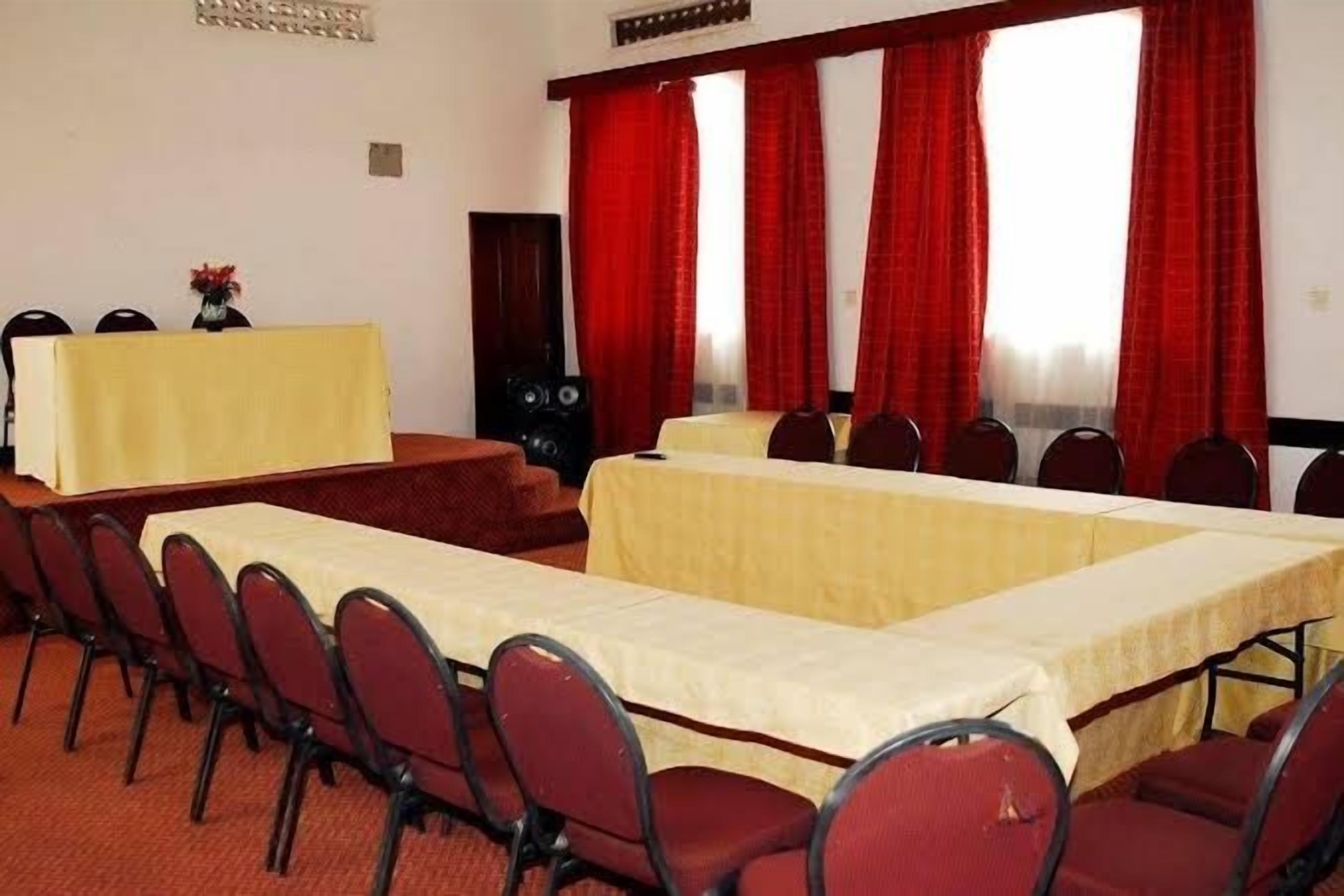 A conference room with a long table, chairs, and a speaker system.