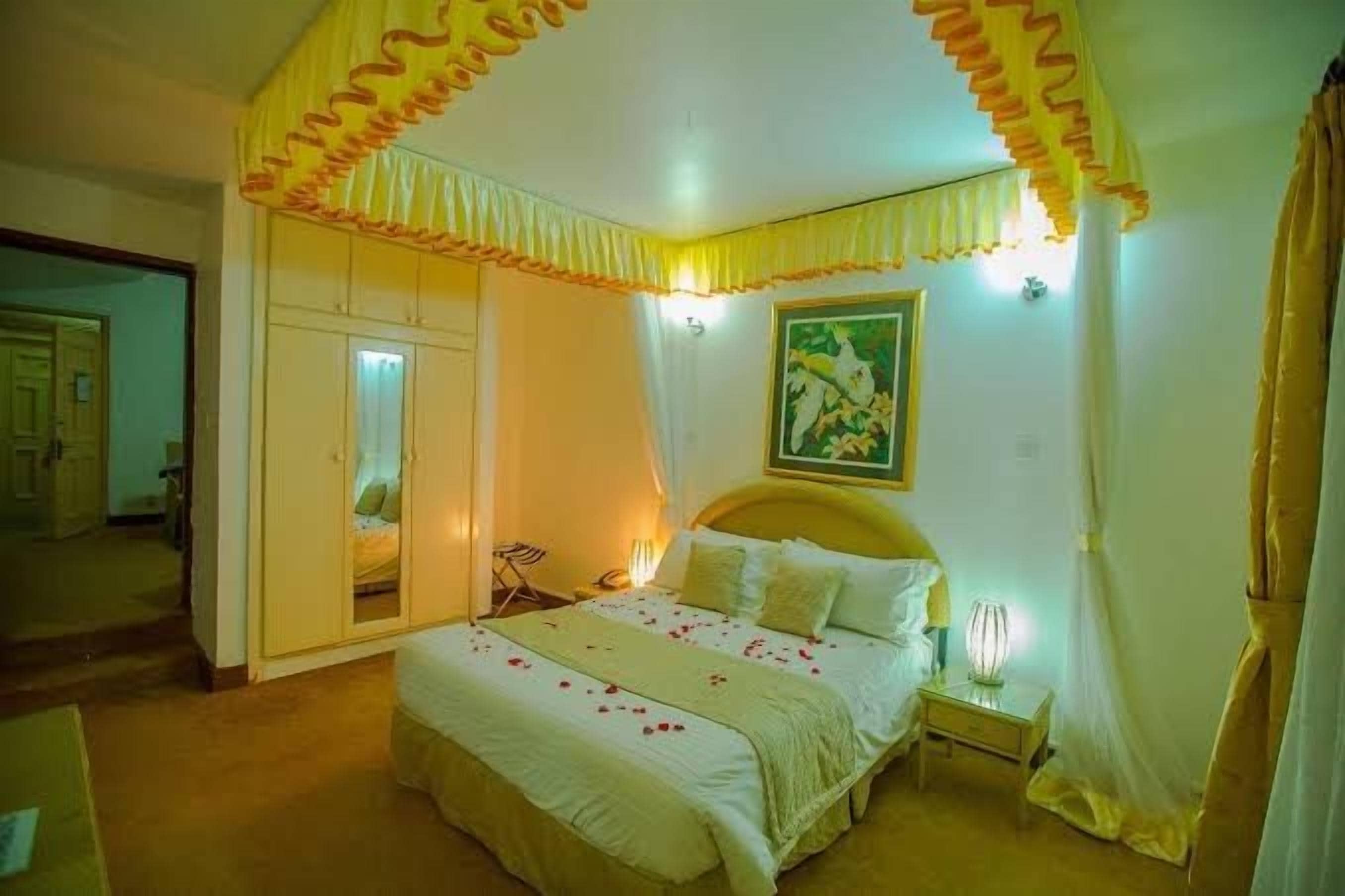 A bedroom with a bed, bedside table, and a mirror.