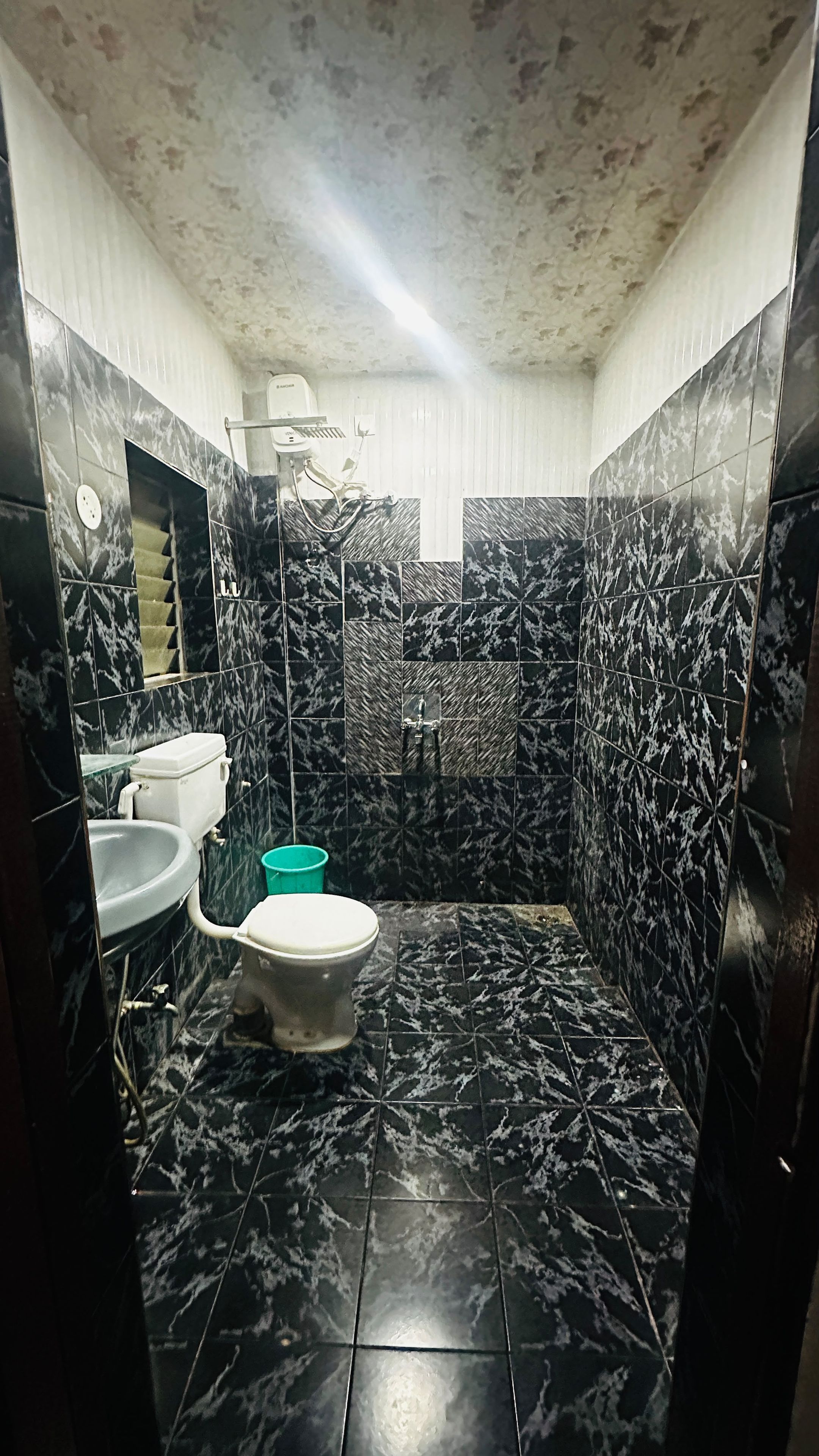 A bathroom with a toilet, sink, and shower area.