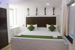 A bedroom with a bed, pillows, a headboard, and wall-mounted decorations. - In the heart of Goa, where the rhythm of the waves meets the melody of the villa (Calangute)