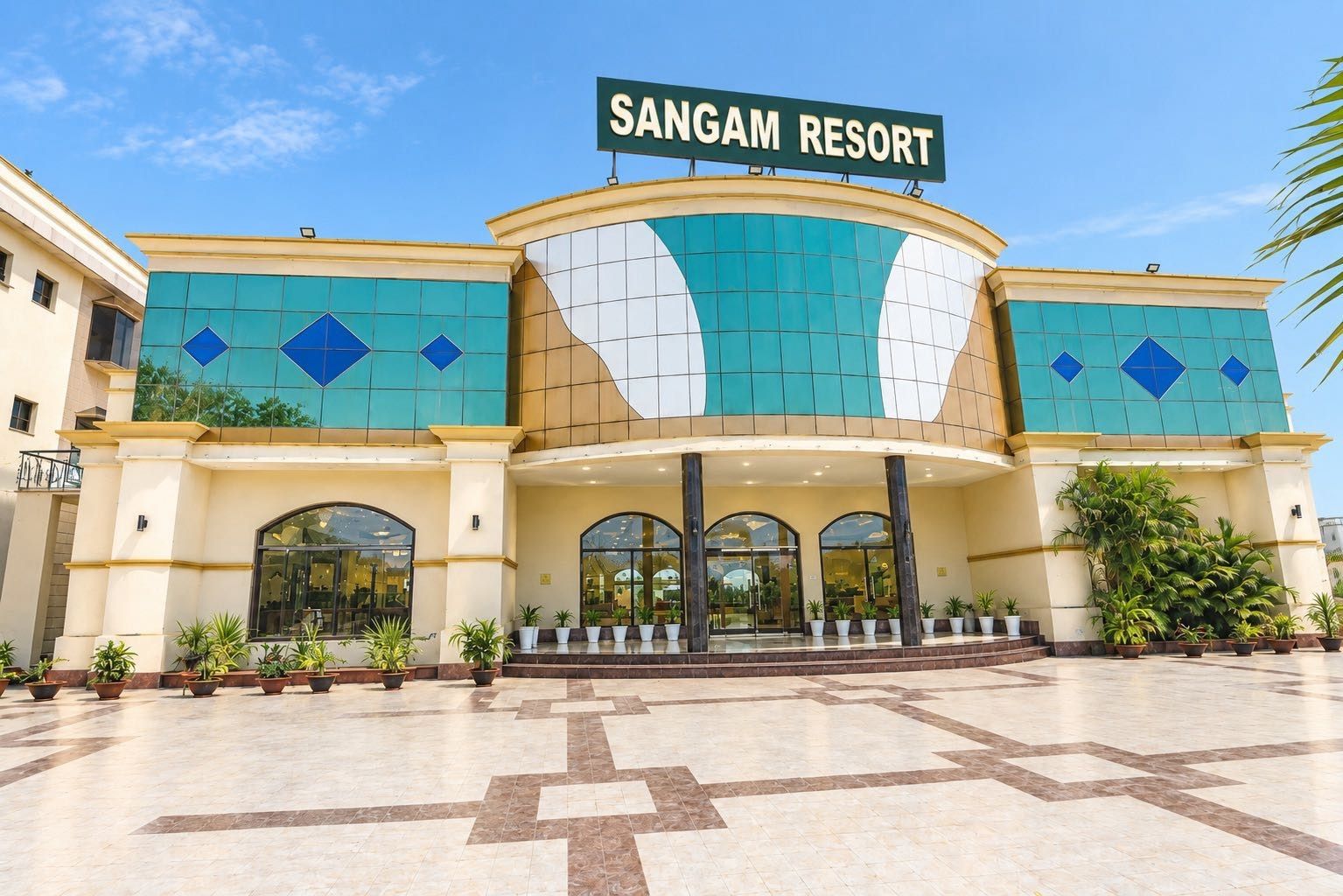 A large building with a sign reading 'SANGAM RESORT' and a covered entrance area.
