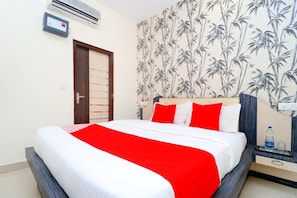 Habitación de hotel con una cama, una mesita de noche, un equipo de aire acondicionado, una puerta y una pared con diseño de bambú.