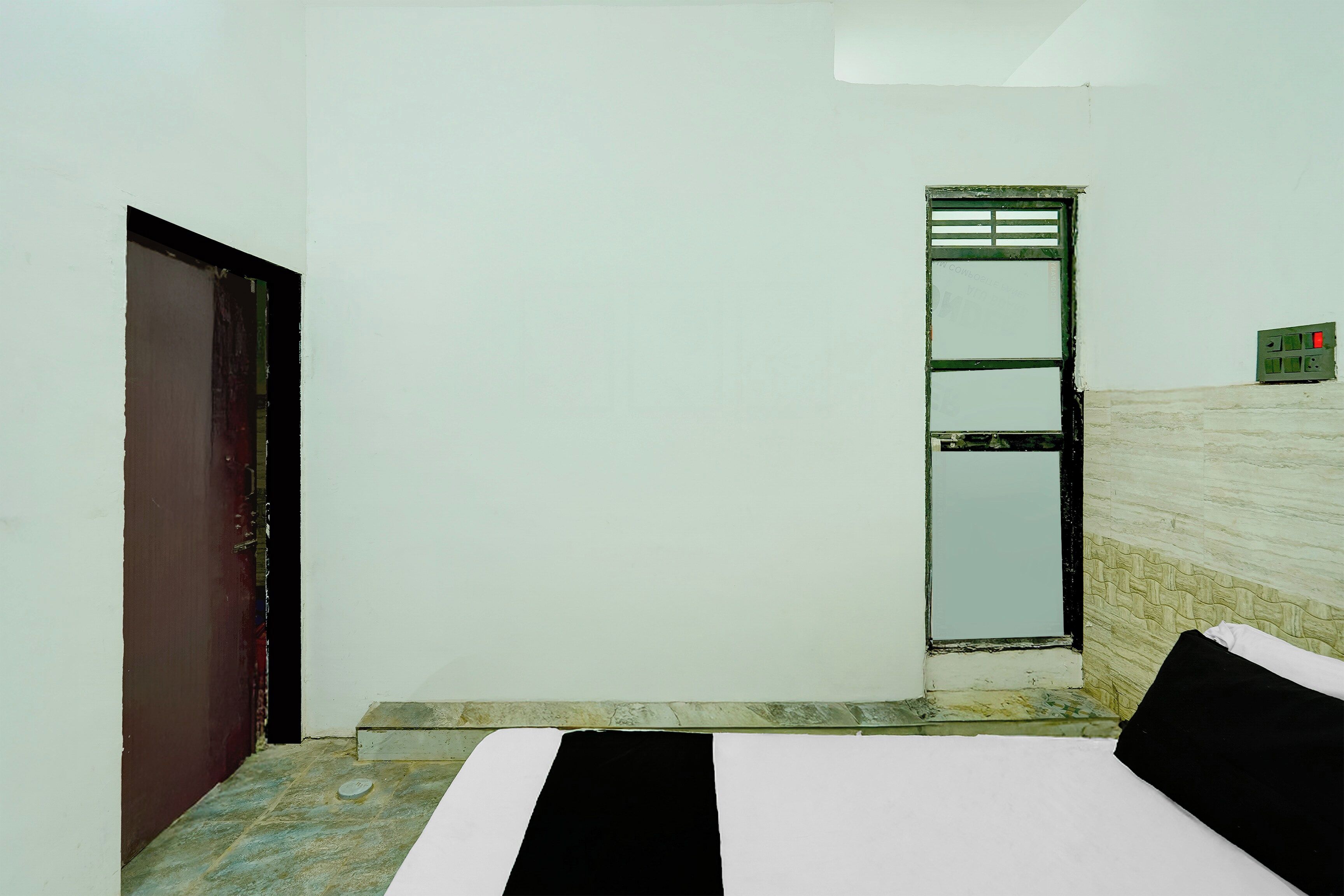 Una habitación pequeña y sencilla con una cama, una puerta y una ventana.
