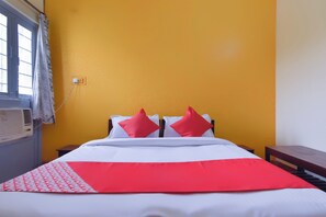 A bed with white bedding and two red pillows, a red blanket, and a window with a curtain. - Hotel O Aditya (Alwar)