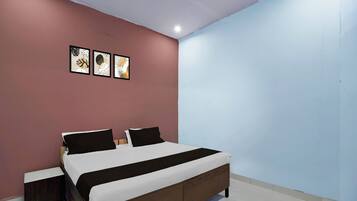 Un dormitorio con una cama, dos mesitas de noche y una pared con tres obras de arte enmarcadas.