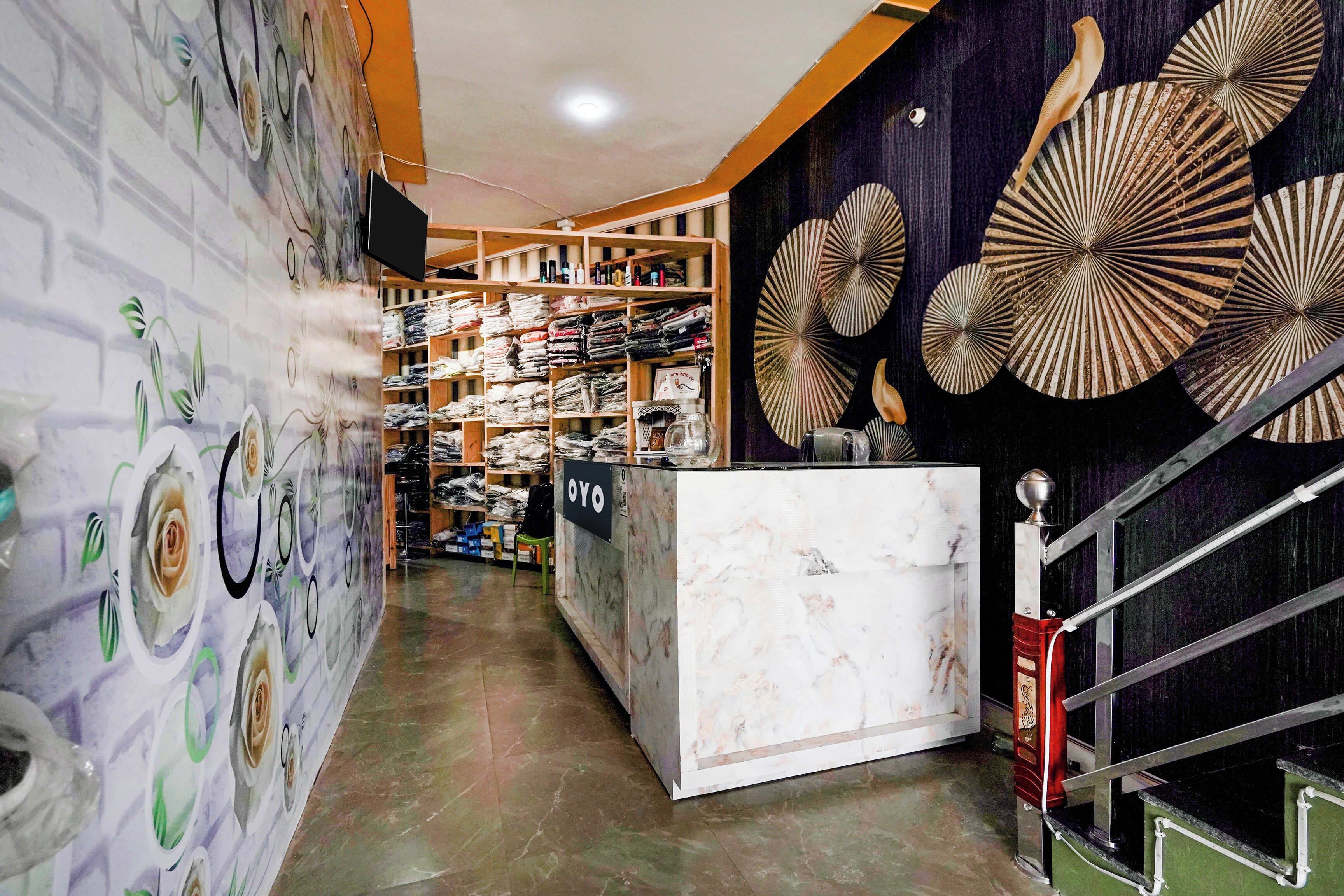 Una tienda minorista con estantes llenos de artículos doblados, una barra de mármol y decoración mural.