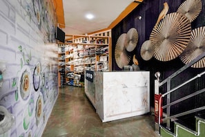 Una tienda minorista con estantes llenos de artículos doblados, una barra de mármol y decoración mural.
