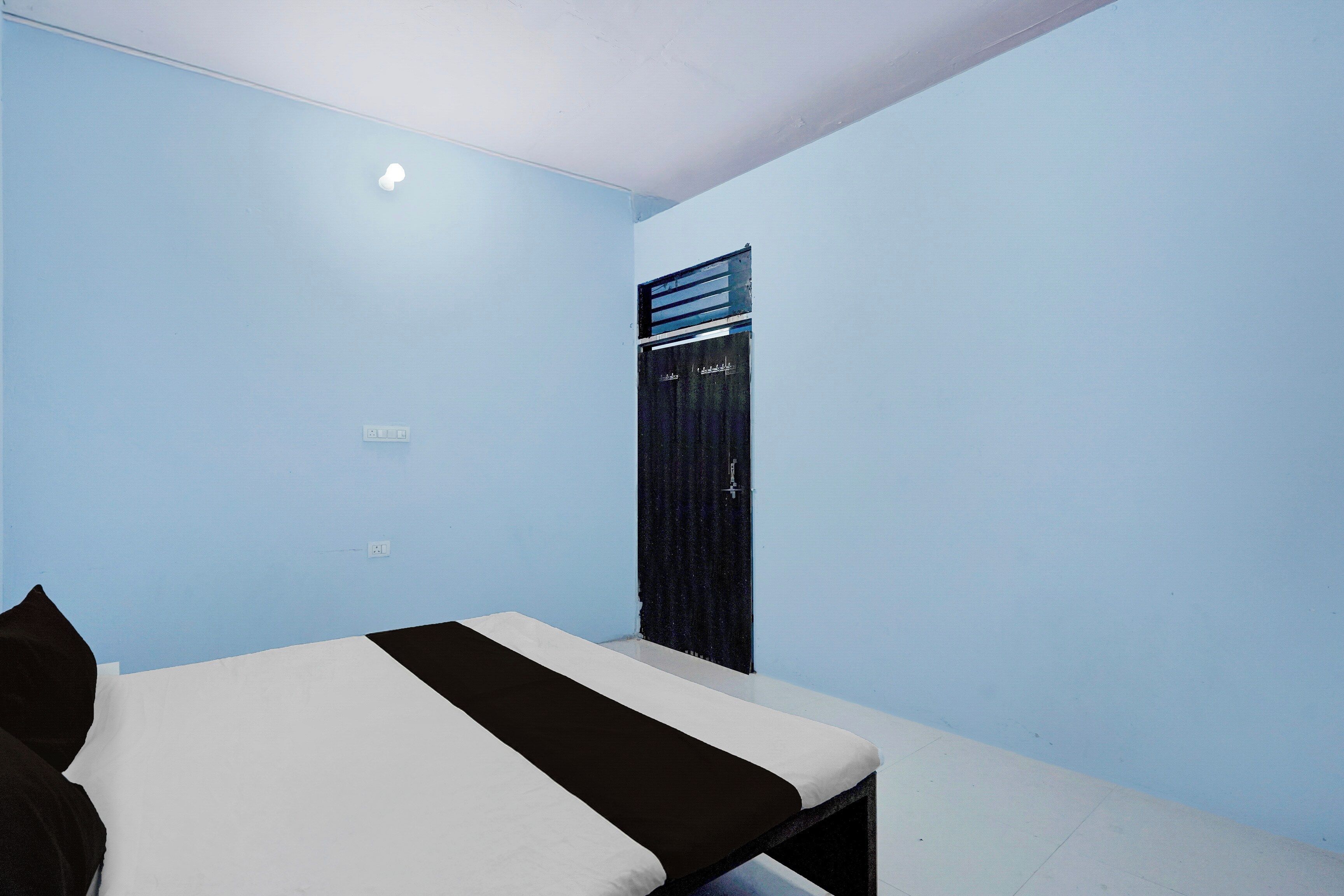 Een kamer met een bed, een raam en een deur.