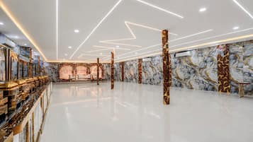 A spacious lobby with a marble floor, a reception desk, and a decorative backdrop.