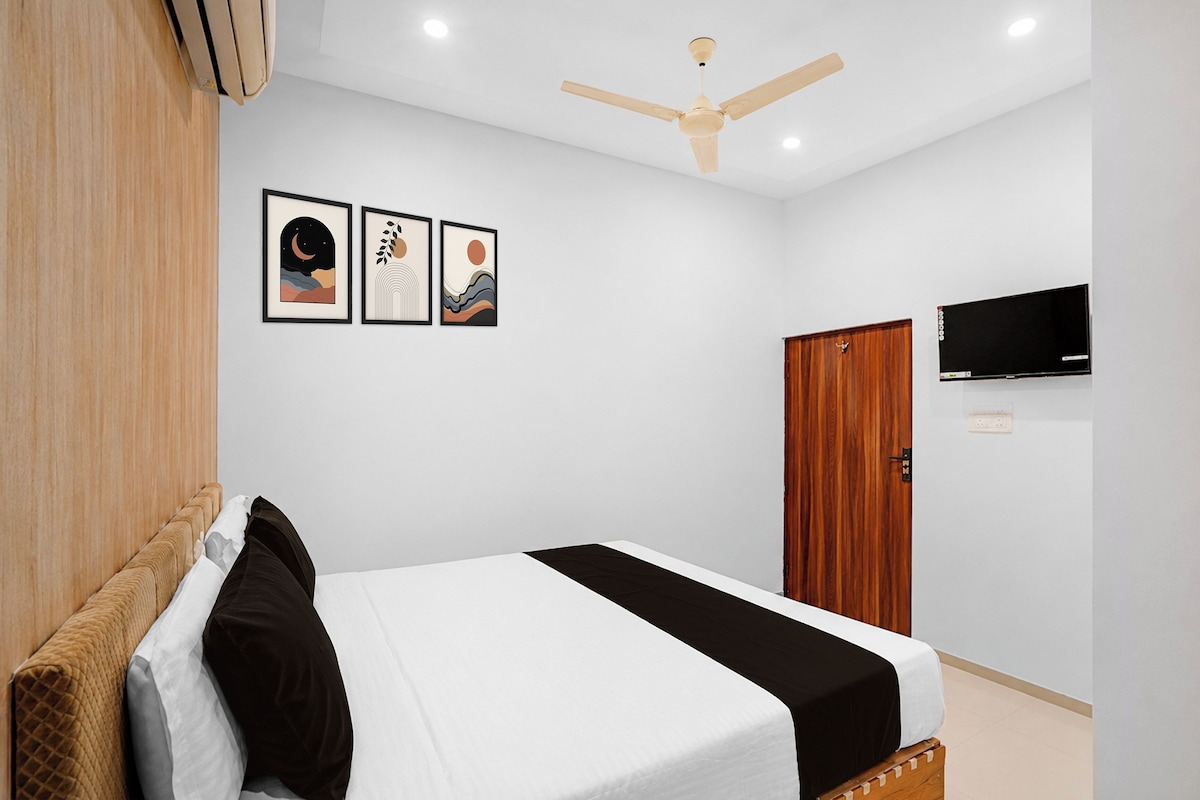 Ein Schlafzimmer mit einem Bett, einem Deckenventilator, einem Fernseher und drei gerahmten Kunstwerken an der Wand.