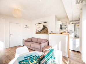 Ein modernes Wohnzimmer mit einer Couch, einem Wandbild und einem Scrabble-Spiel.