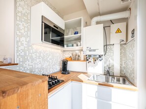 Eine moderne Küche mit Backofen, Kaffeemaschine und Spüle.