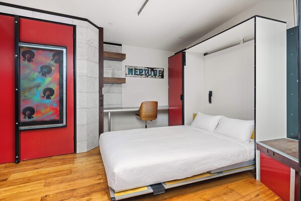A modern bedroom with a bed, a red wardrobe, a wooden chair, and a wall-mounted shelf. - The Curious Nook - Balaclava Stay (Balaclava)