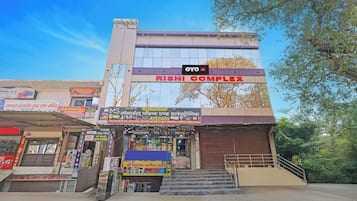 A hotel complex with multiple shops on the ground floor, including a mobile phone and electronics store.