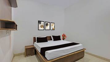 A bedroom with a wooden bed, a nightstand, and a wall-mounted shelf.