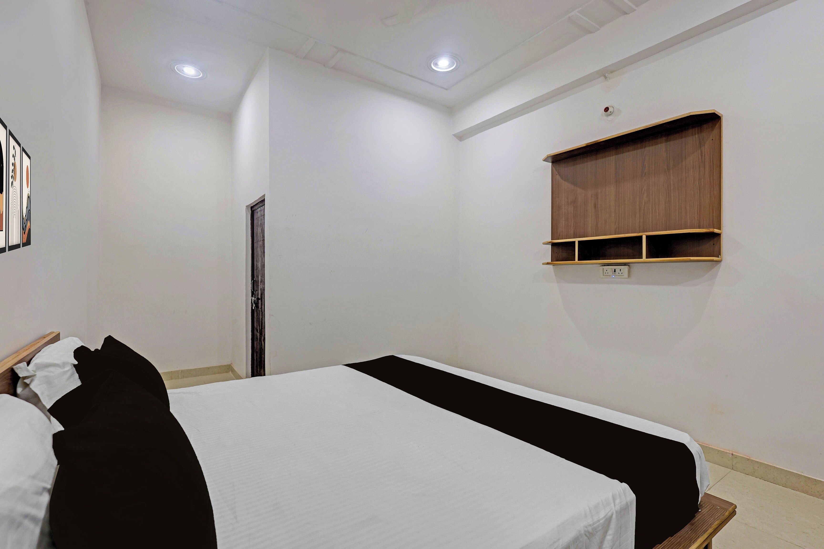 A room with a bed, a wooden shelf, and a door.