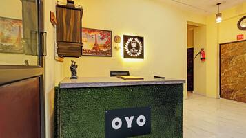 A reception desk with a sign reading 'OYO' in a hotel lobby.