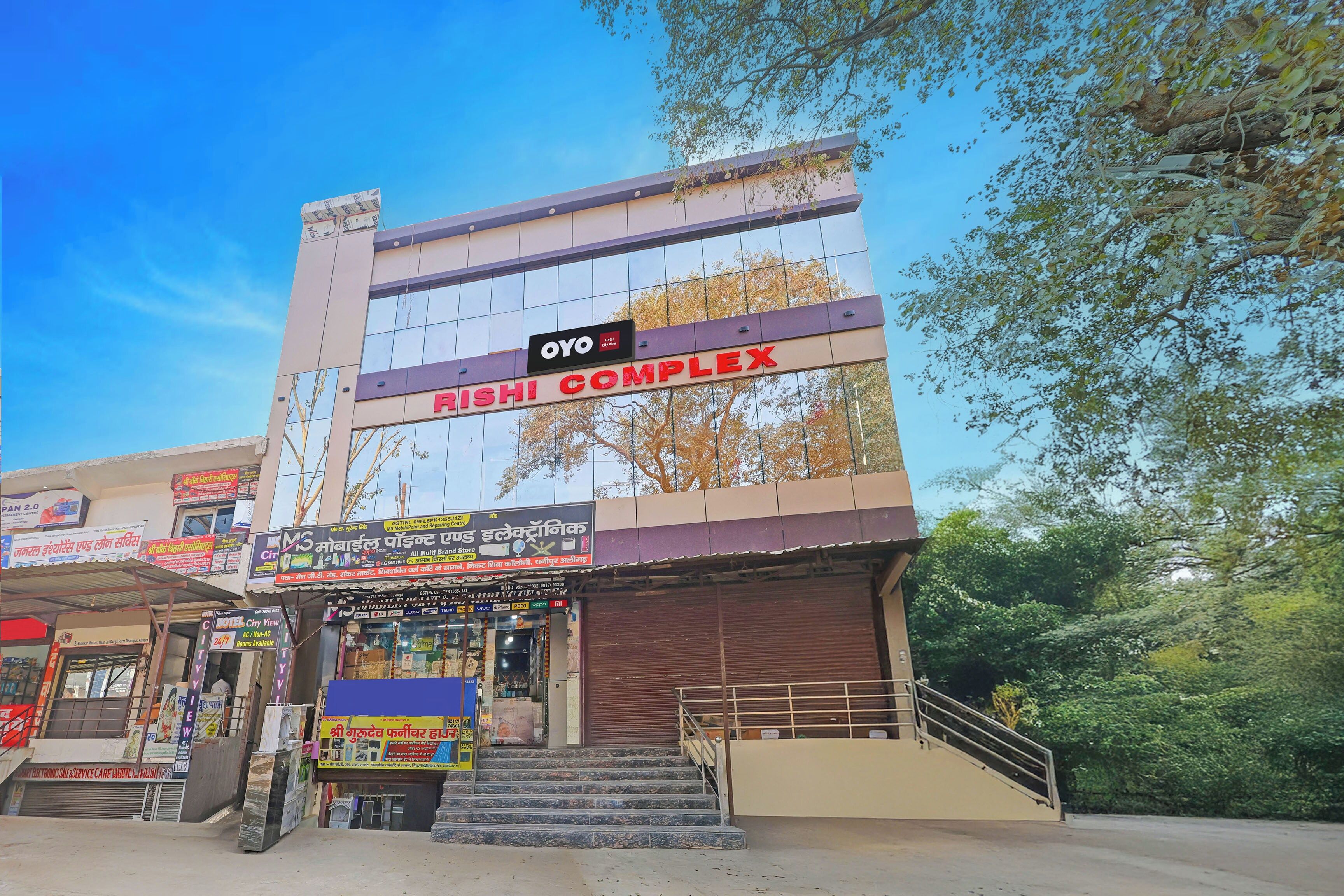 A building with a sign for 'Rishi Complex' and 'Oyo City View' hotel.