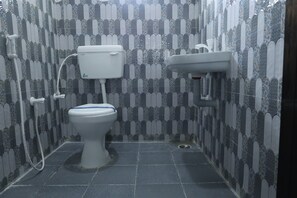 A bathroom with a toilet, a sink, and a shower. - The Golden Park (Dindigul)