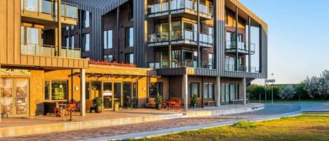 Een meerlaags hotel met een modern ontwerp, met balkons en grote ramen.