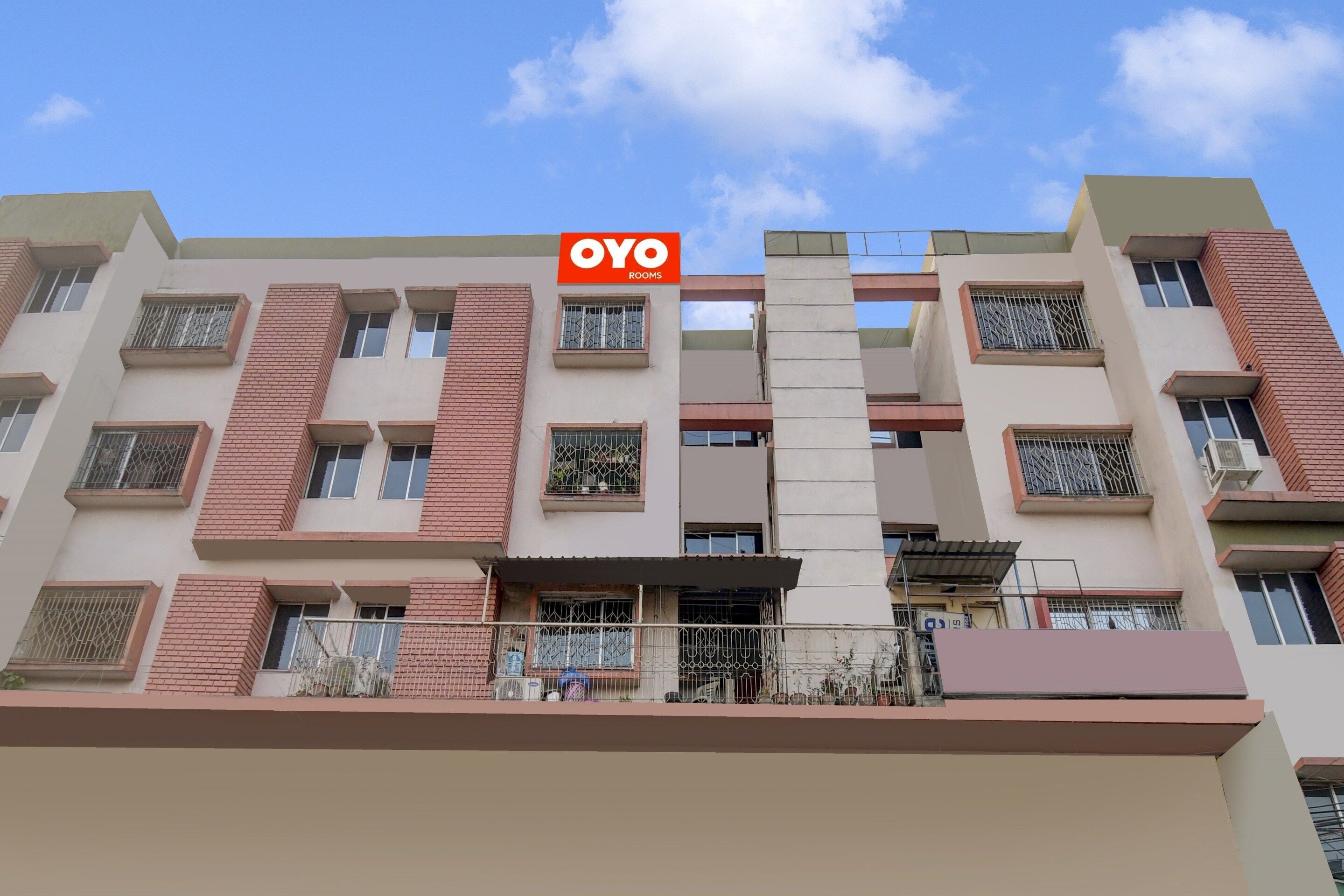 Um edifício de vários andares com uma placa indicando 'OYO ROOMS', sinalizando um hotel ou acomodação.