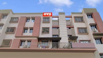 Um edifício de vários andares com uma placa indicando 'OYO ROOMS', sinalizando um hotel ou acomodação.