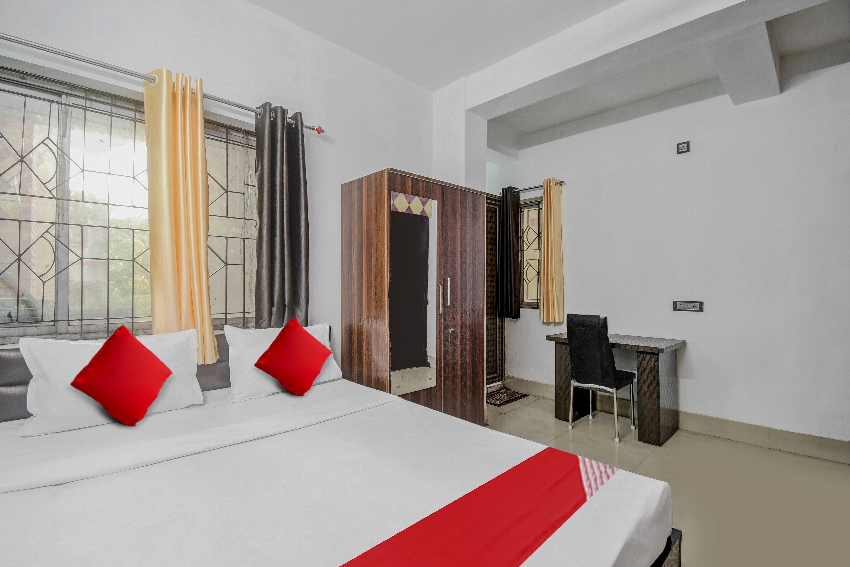 A hotel room with a bed, a desk, and a chair.