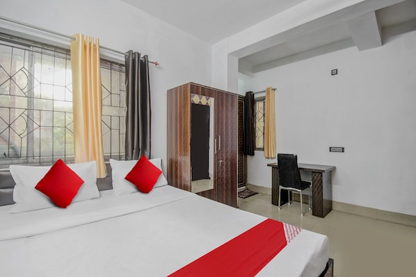 A hotel room with a bed, a desk, and a chair.