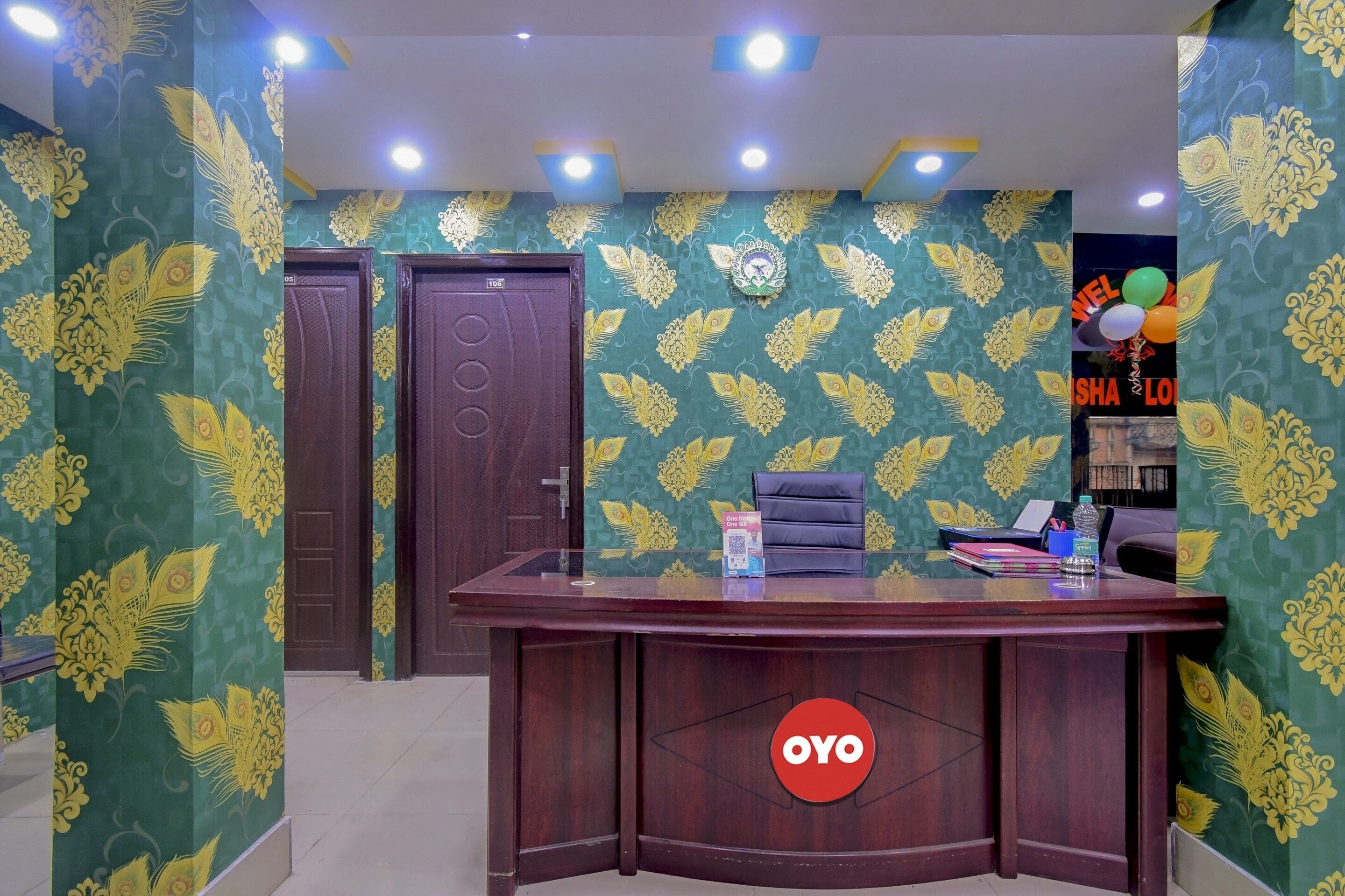 Una reception con un logo, una porta chiusa e un muro decorato.