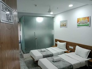A hotel room with two beds, a wardrobe, and a door marked 'SHATWEEK 104'. - Hotel O SHATWEEK (Ankleshwar)