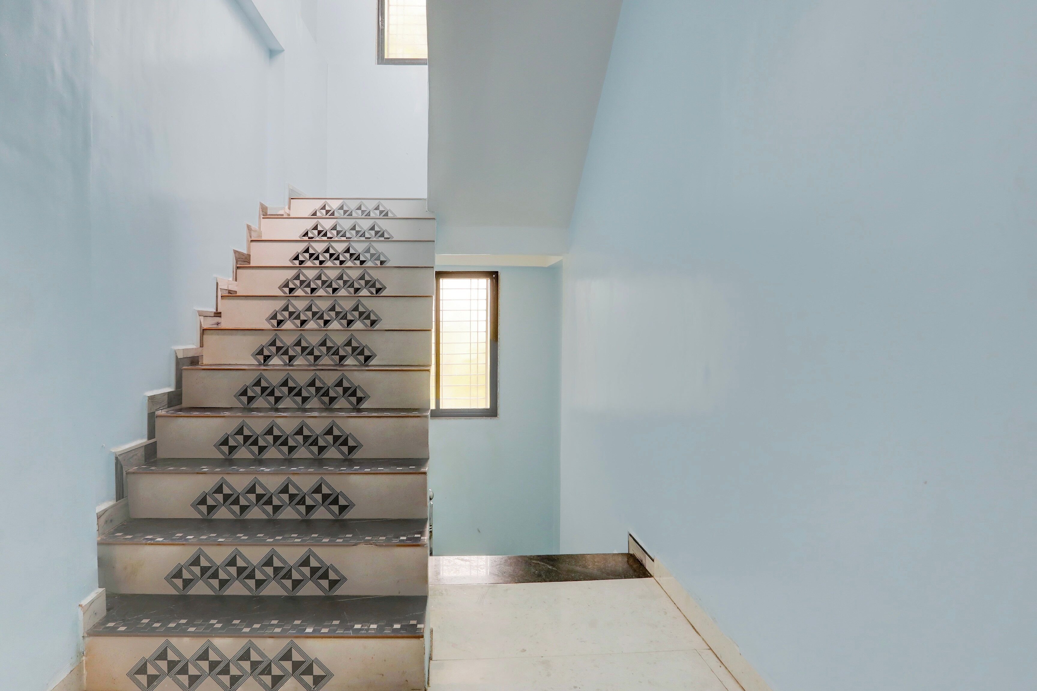 Una escalera con patrones geométricos en los peldaños que lleva a una plataforma.